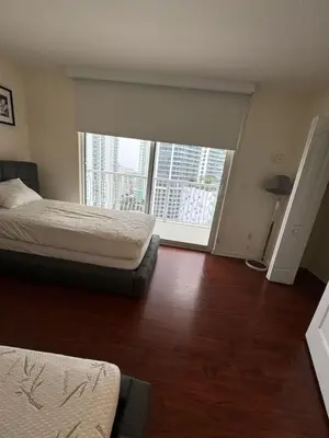a bedroom with two beds and a large window at Bright 2BR Apartment in Prime Brickell Location in Miami