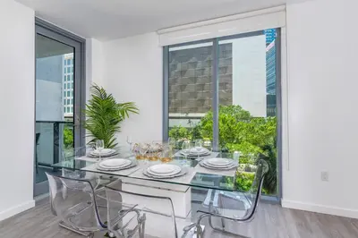 a dining room with a glass table and chairs at Spacious and bright in the heart of Brickell in Miami