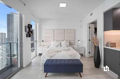 a white bedroom with a large bed and a large window at Downtown Vibes Pool Gym & Oceanview in Miami