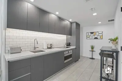 a kitchen with gray cabinets and a sink at Downtown Vibes Pool Gym & Oceanview in Miami