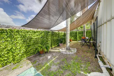 a patio with a fence and a tree with a canopy at Mod Bungalow with Ultra-Private Outdoor Hang Space! in Miami Gardens