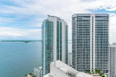 two tall buildings next to the water in front of the ocean at Fantastic APT Brickell in Miami