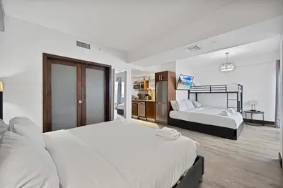 a hotel room with two beds and a desk at Heart of South Beach Balcony Rooftop Pool in Miami Beach