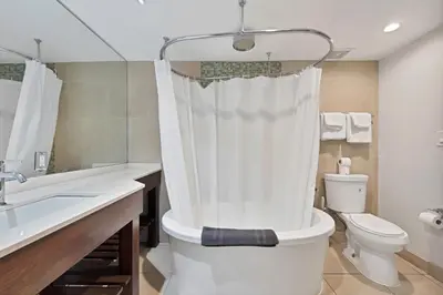 a white bathroom with a toilet and a sink at Heart of South Beach Balcony Rooftop Pool in Miami Beach