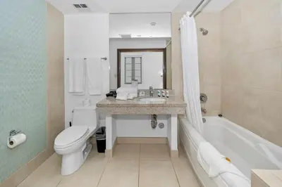 a bathroom with a sink and a toilet and a tub at Steps from the Ocean Comfy Studio with King Bed in Miami Beach