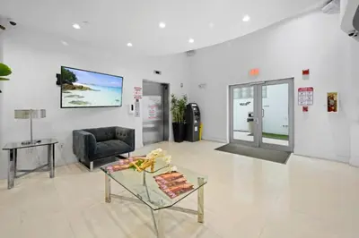 a living room with a chair and a glass table at Steps from the Ocean Comfy Studio with King Bed in Miami Beach