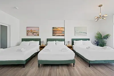three beds in a room with white walls at Stylish Studio in South Beach with Ocean Views in Miami Beach