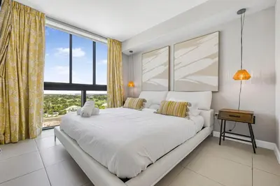 a bedroom with a large bed and a large window at Modern Doral Condo w Free Parking in Miami