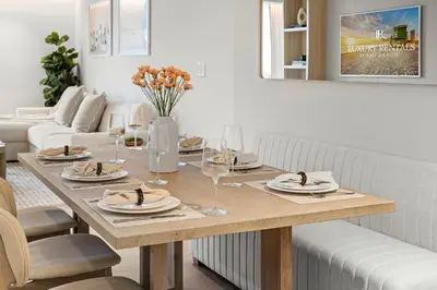 a dining room table with plates and wine glasses at 2 Bedroom Private Residence at Roney Palace -630 in Miami Beach