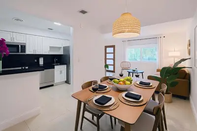 a kitchen and dining room with a table with a bowl of fruit at Stylish 2BR Getaway - Prime Miami Location in Miami