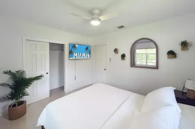 a white bedroom with a large bed and a window at Stylish 2BR Getaway - Prime Miami Location in Miami
