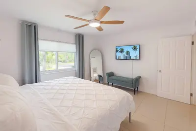a bedroom with a white bed and a ceiling fan at Stylish 2BR Getaway - Prime Miami Location in Miami