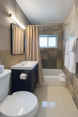 a bathroom with a toilet and a sink and a tub at Stylish 2BR Getaway - Prime Miami Location in Miami