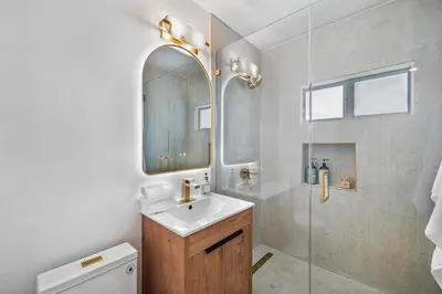a bathroom with a sink and a mirror and a shower at Chic Villa Nina 2 bedrooms 2 baths in Miami! in North Miami