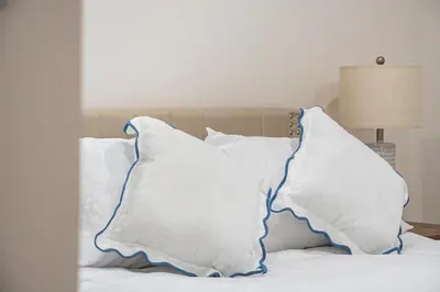 a bed with white pillows on top of it at Chic Villa Nina 2 bedrooms 2 baths in Miami! in North Miami