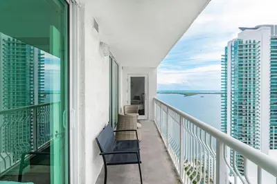 a balcony with chairs and a view of the ocean at 3 bedroom stunning apt brickell in Miami