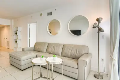 a living room with a couch and two round mirrors at Bayside Miami High-Rise Condo By Waterfront Park! in Miami