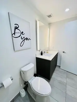 a bathroom with a toilet and a sink and a mirror at Miami Downtown 2BR Pool-Gym-Views-Great Location in Miami