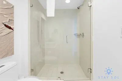 a shower with a glass door in a bathroom at Infinite Views - Private Balcony -Poolside Bliss Near the Beach in Hallandale Beach
