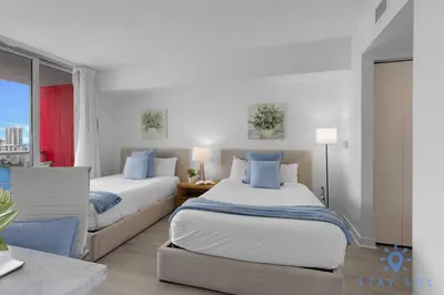 a bedroom with two beds and a window at Infinite Views - Private Balcony -Poolside Bliss Near the Beach in Hallandale Beach