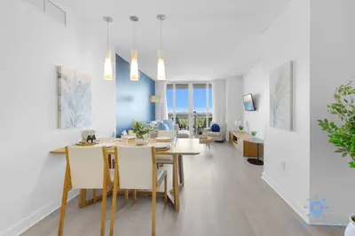 a dining room and living room with a table and chairs at Balcony with Infinite Views - Poolside Comfort in Hallandale Beach