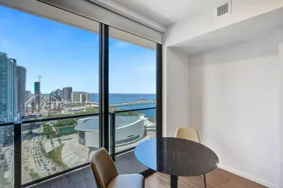 a room with a table and chairs and a large window at Lux Miami Studio City Bay Views in Miami