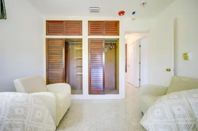 a living room with two white chairs and a door at Less Than 3 Mi to Hard Rock Stadium Miami Home with Sunroom in Miami