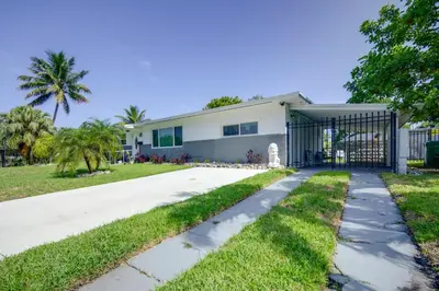a driveway leading to a house with a gate at Less Than 3 Mi to Hard Rock Stadium Miami Home with Sunroom in Miami