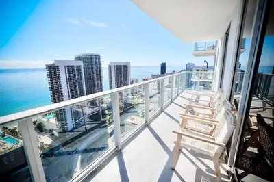 a balcony with a chair and the ocean at 2 BDR Stunning Ocean View in Hyde Beach House in Hollywood