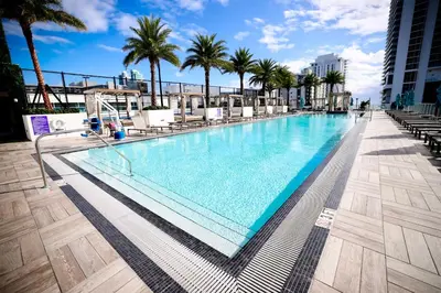 a swimming pool on the roof of a building with palm trees at 2 BDR Penthouse Ocean Front View Hyde Beach House in Hollywood