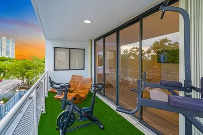 a gym with a bench on a balcony at Waterfront 3bed | Pool | 10min walk to Beach in Hallandale Beach