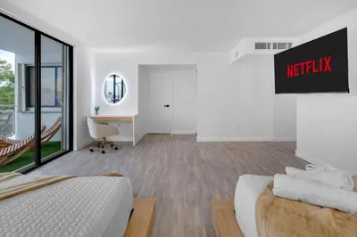 a white room with a bed and a desk and a chair at Waterfront 3bed | Pool | 10min walk to Beach in Hallandale Beach