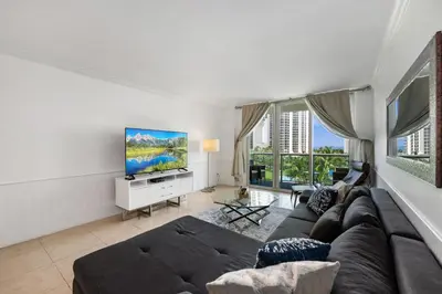 a living room with a couch and a flat screen tv at Bright Stylish 2BR Condo Stunning View Of Ocean in Sunny Isles Beach