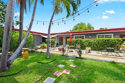 a garden with palm trees and a building at 1BR Studio Parking, Pet Friendly and BBQ Area in Hollywood