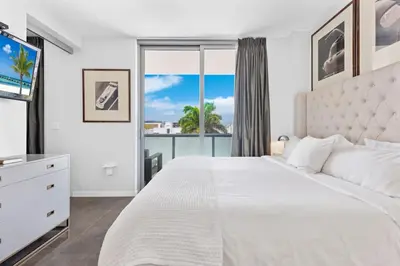a white bedroom with a large bed and a large window at Large Beach Suite Rooftop Pool by Convention Center in Miami Beach