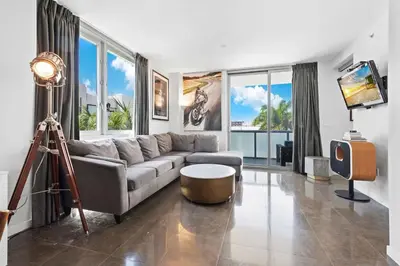 a living room with a couch and a tv at Large Beach Suite Rooftop Pool by Convention Center in Miami Beach