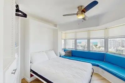 a blue bench in a room with windows at Miami Lux Haven in Miami Beach