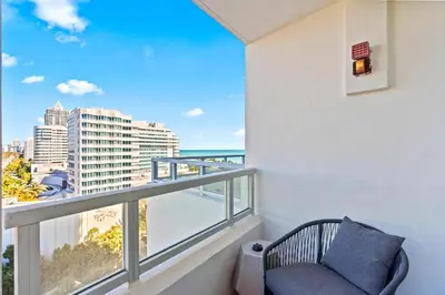 a balcony with a chair and a view of the city at Luxury Condo at Trésor Miami Beach in Miami Beach