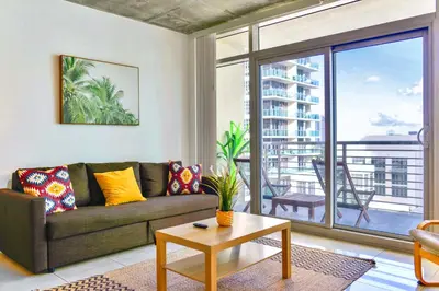 a living room with a couch and a large window at Miami Midblock Condo - City Views, Pool & Balcony! in Miami