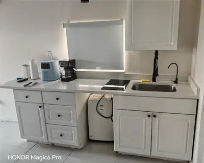 a kitchen with white cabinets and a sink and a stove at Tempurpedic Queen - Laundry, Parking & EV Charger in Hollywood