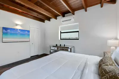 a white bedroom with a large white bed and a window at Hidden Bungalow- Peaceful retreat BBQ and hot tub in Miami
