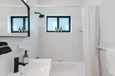 a white bathroom with a sink and a mirror at Hidden Bungalow- Peaceful retreat BBQ and hot tub in Miami