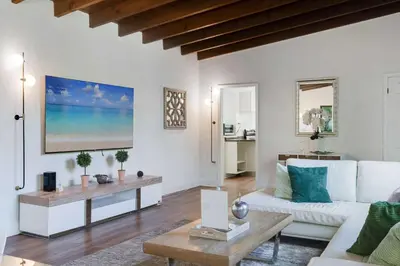 a living room with a white couch and a table at Hidden Bungalow- Peaceful retreat BBQ and hot tub in Miami