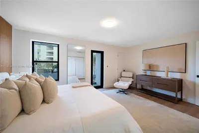 a large white bedroom with a large bed and a desk at Oceanview Crespi Villa in Miami Beach