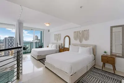 two beds in a white room with a window at Brickell River Views- modern amenities in the city in Miami