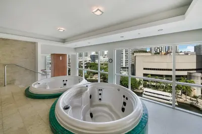 two bath tubs in a bathroom with a large window at Brickell River Views- modern amenities in the city in Miami