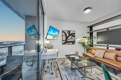 a living room with a couch and a large screen at Modern Studio City Views in Miami