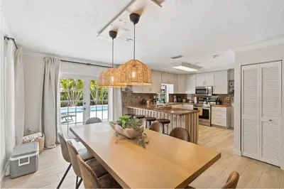a kitchen and dining room with a table and chairs at Boho Style 5 BR 2,5 BT Heated Pool Fit 14 in Miami