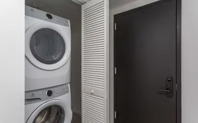 a laundry room with a washer and dryer next to a door at Heart of Downtown Miami in Miami