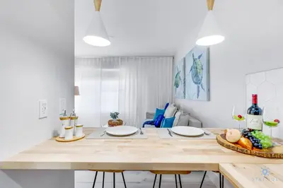 a kitchen with a large wooden table with two chairs at Spacious Apt 2 Blocks to Beach and Collins Park in Miami Beach